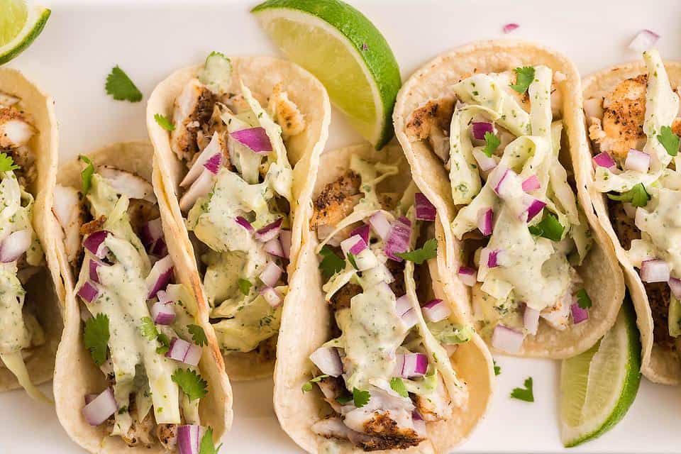 Fish tacos on a white platter.